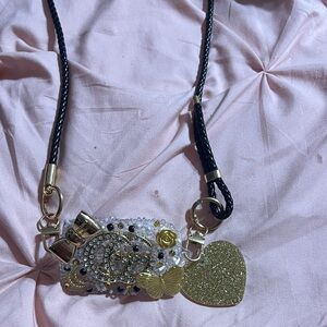 Gold and Black Phone Attachment with crossbody Strap and Heart Charm.